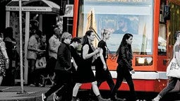 People walking in front of a city bus
